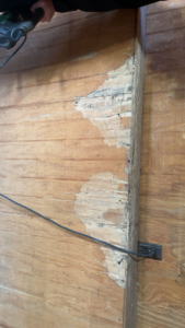 A damaged wooden wall showing signs of pest infestation, treated by Best Termite & Pest Control, Inc. in Manchester, KY.