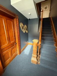 A dark blue carpeted staircase and hallway installed by Concord Carpet Center LLC in Concord, NH