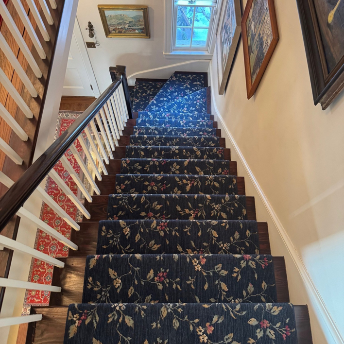 A dark blue floral patterned stair runner expertly installed by Kaoud Rugs in West Hartford, CT
