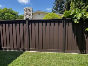 A newly installed dark brown composite privacy fence in a residential backyard by True American Fence Supply and Construction in Anaheim, CA.