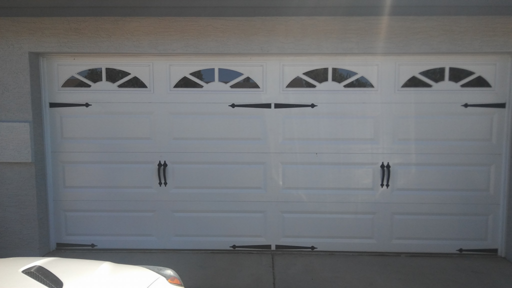 A modern dark brown garage door with decorative panels and handles installed by The Garage Door Kings in Peoria, AZ