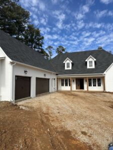 Dark brown garage doors installed on a white brick house by Platinum Garage Door Services in Helena, AL