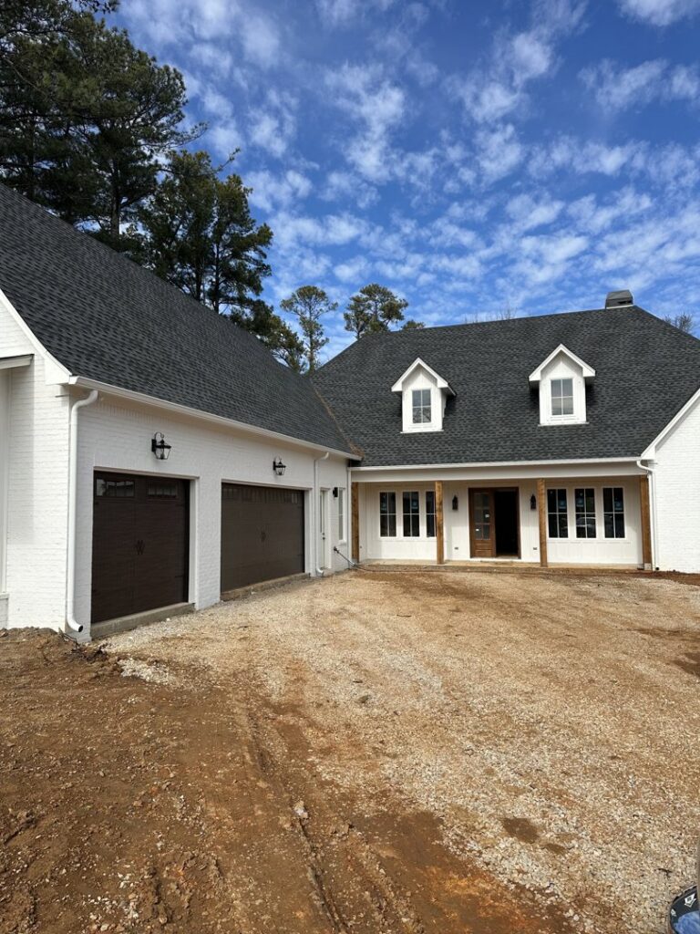 Dark brown garage doors installed on a white brick house by Platinum Garage Door Services in Helena, AL