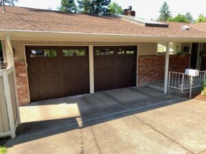 Two dark brown garage doors with windows installed by Revolution Garage Door, LLC in Corvallis, OR.