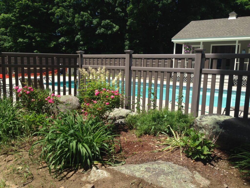 A dark brown fence installed around a swimming pool for safety and privacy by Brodeur-Campbell Fence Co. in Springfield, MA.