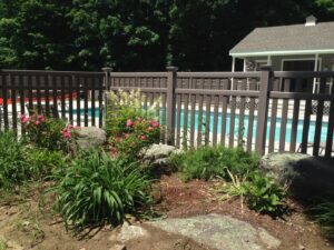 A dark brown fence installed around a swimming pool for safety and privacy by Brodeur-Campbell Fence Co. in Springfield, MA.