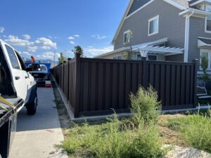 A newly installed dark brown privacy fence alongside a residential property by All Over Fence Idaho in Jerome, ID