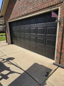A newly installed dark brown residential garage door by Garage Door Specialists Of Oklahoma Inc. in Oklahoma City, OK
