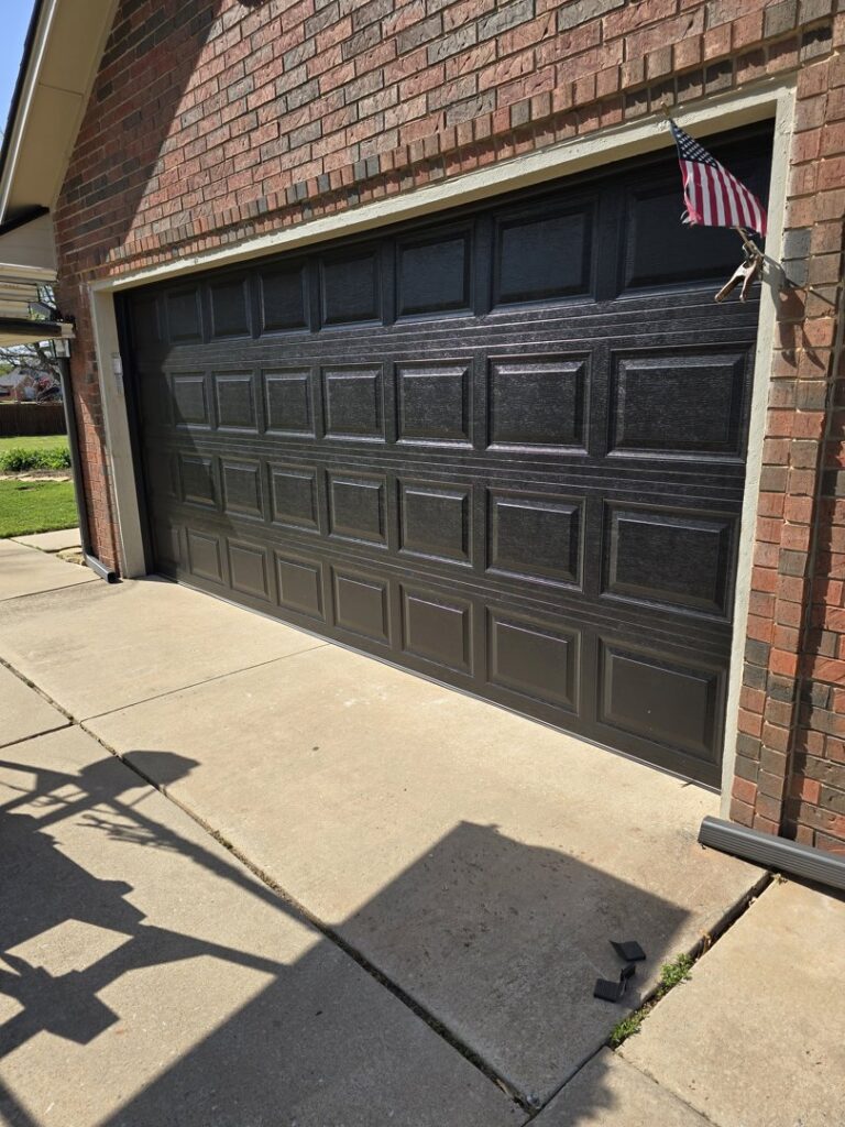 A newly installed dark brown residential garage door by Garage Door Specialists Of Oklahoma Inc. in Oklahoma City, OK