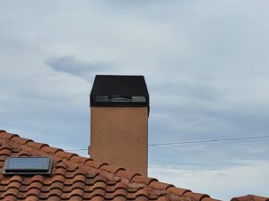 A dark chimney cap installed on a tiled roof by SWFL Chimney Caps Inc. in Fort Myers, FL.