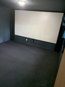 A home theater room featuring dark gray carpet installed by Fairbanks Carpets Plus in Fairbanks, AK