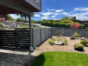 A dark gray horizontal slat fence with a matching gate, installed by Webb Fencing Pros in Seattle, WA.