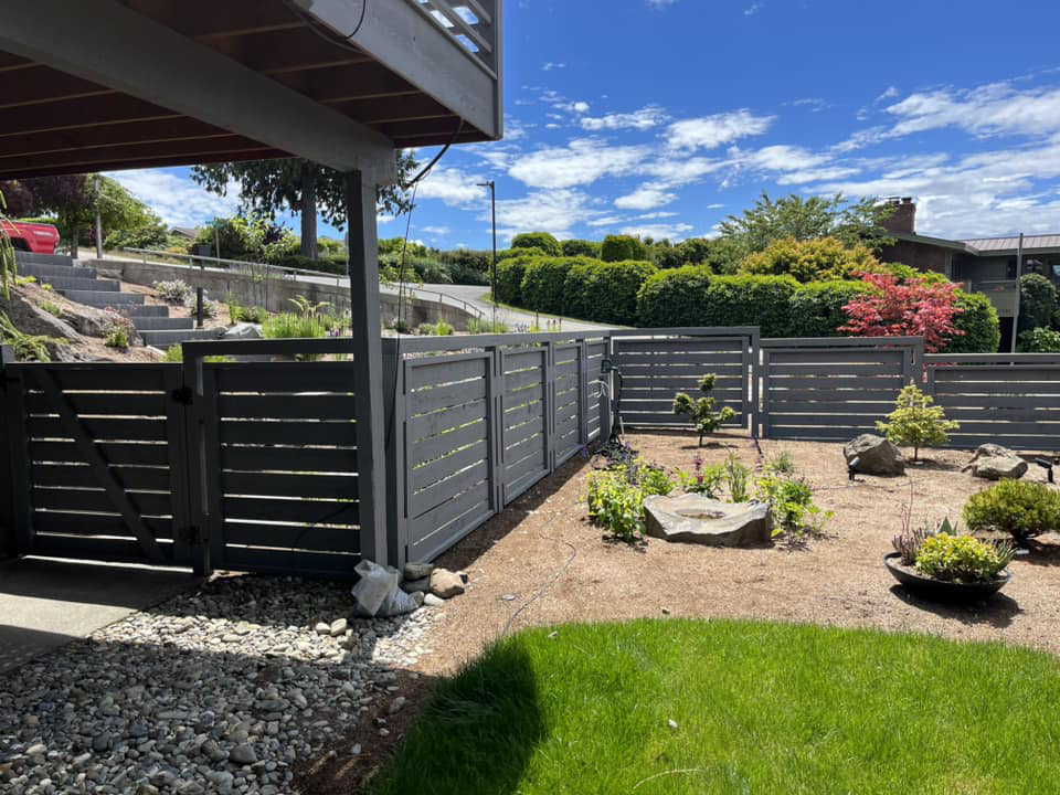 A dark gray horizontal slat fence with a matching gate, installed by Webb Fencing Pros in Seattle, WA.