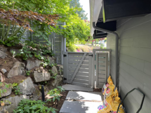 A dark gray horizontal slat fence and gate providing access to a side yard by Webb Fencing Pros in Seattle, WA.