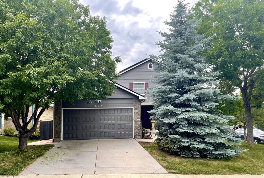 A modern dark gray panel garage door installed on a residential home by Lion Heart Garage Doors in Thornton, CO.