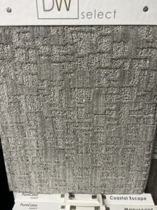 A close-up of a dark gray square pattern carpet sample at West Michigan Flooring & Interiors in Byron Center, MI.