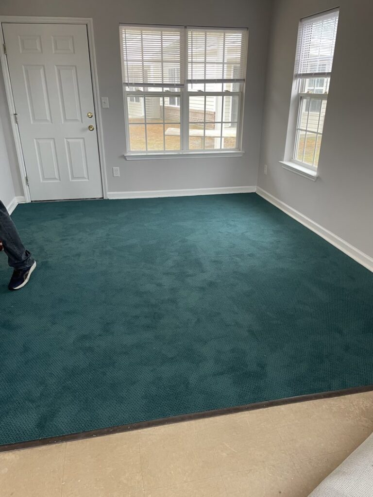 A room with newly installed dark green carpet by Johnson City Flooring & Finish, LLC in Johnson City, TN