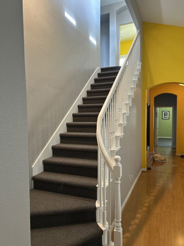 A residential staircase with newly installed dark grey carpet by Floor & More in San Marcos, CA.