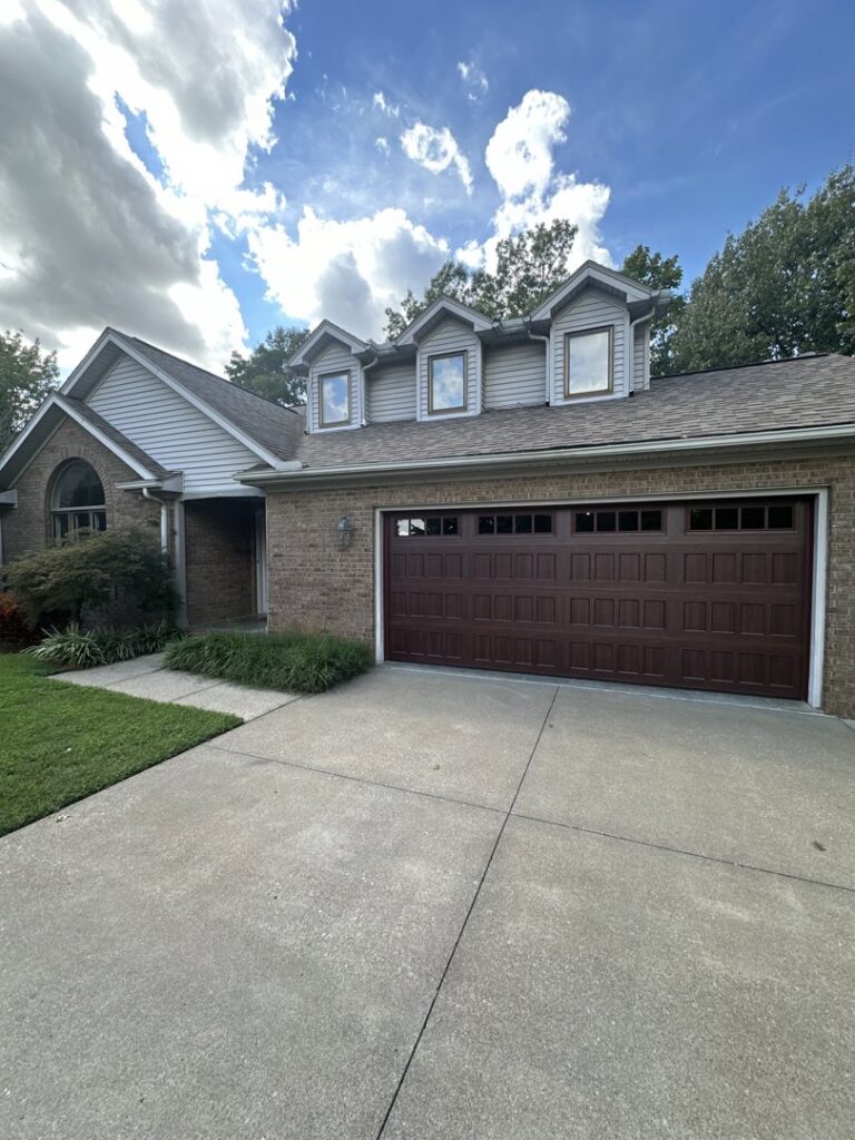 A dark grey garage door installed on a brick house with number 508 by Precision Garage Door of Owensboro Evansville in Owensboro, KY.