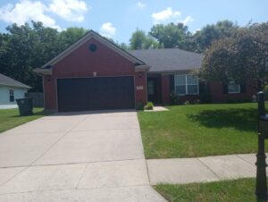A dark grey garage door installed on a residential home by Precision Garage Door of Owensboro Evansville in Owensboro, KY.