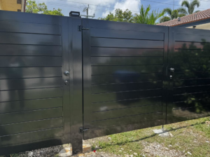 Newly installed dark grey horizontal slat driveway gates by HD Multi Service USA INC, providing security and style in Miami, FL.