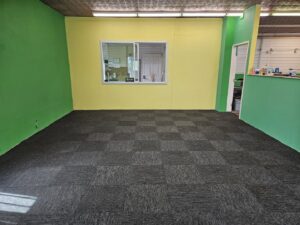 A newly installed dark grey patterned carpet tile floor by Midwest Coast Flooring in North Bend, OR