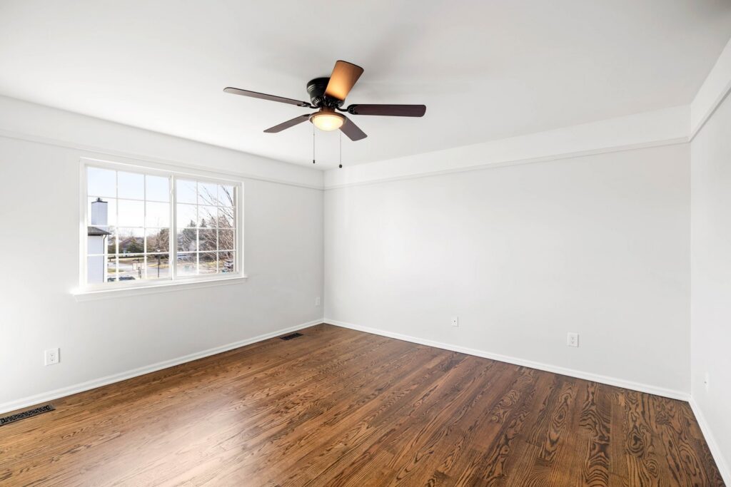 Newly installed dark hardwood flooring in a spacious empty room by Nations Best Flooring & Carpet Co. in Livonia, MI.