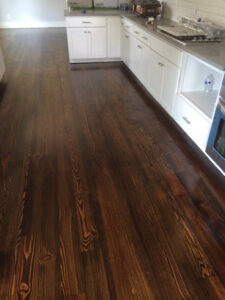 Dark hardwood flooring installed in a modern kitchen by Peach Design Inc., a carpet contractor in Atlanta, GA.