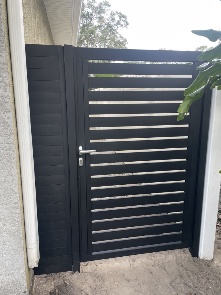 A newly installed dark slatted pedestrian gate by New Euro Fences CA in Sacramento, CA.