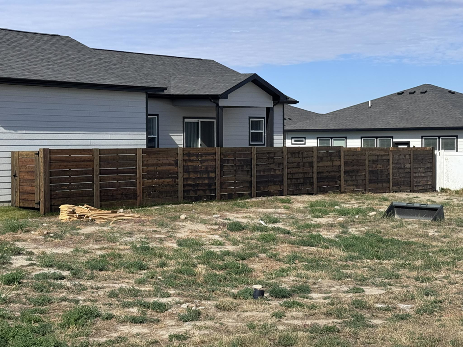 A dark stained horizontal slat wooden fence installed by Nailed It Fencing for a home in Williston, ND.