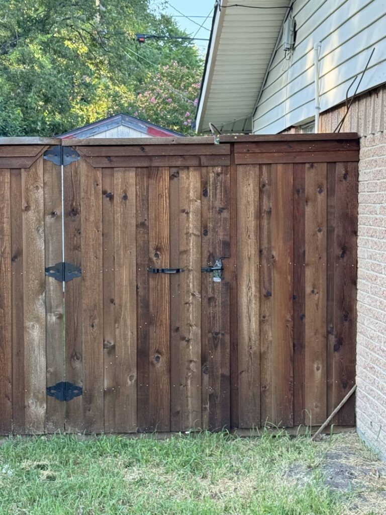A dark stained wood fence gate with black hinges and latch, installed by Dallas Fence in Dallas, TX.
