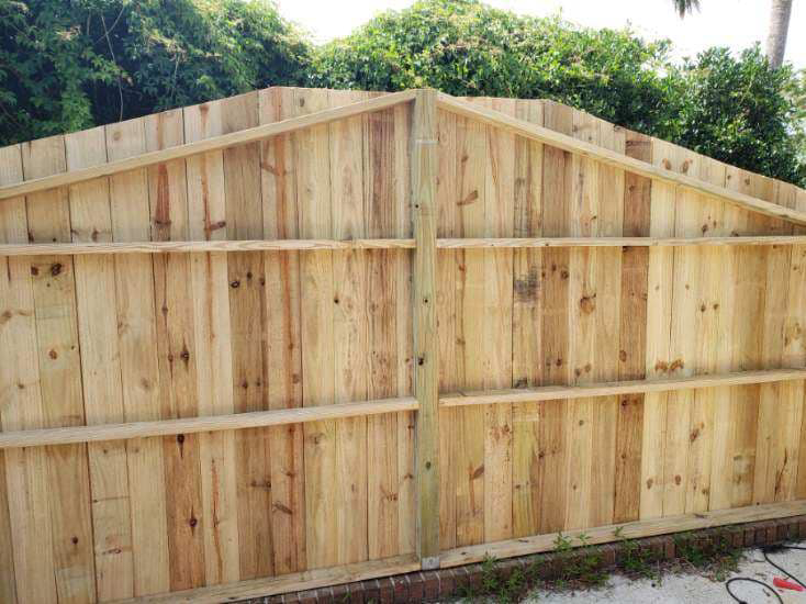 A dark-stained wood post and rail fence in a large field by Melanie K. Lynch in Crawfordville, FL