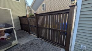 A dark-stained wooden privacy fence and gate installed by Gifford Contracting & Repair - Custom Privacy Fencing in Goose Creek, SC.