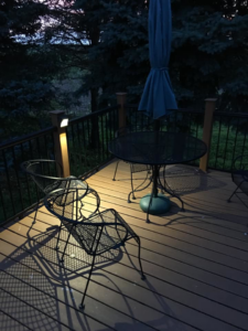 A deck with elegant post lighting installed by McPhillips Electric LLC in Columbus, NE, creating a warm ambiance at dusk.