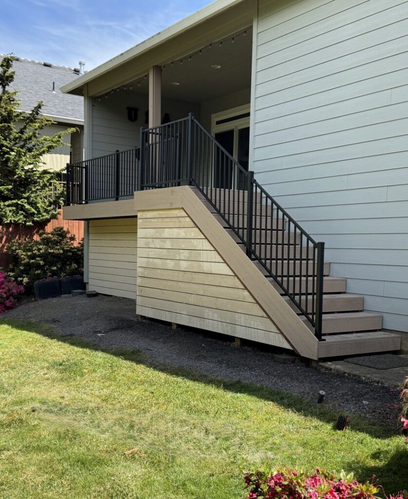 A residential deck with stairs and black metal railings, installed by Clark County Fence LLC in Vancouver, WA.