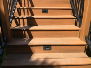 Close-up of deck stairs featuring integrated step lights installed by McPhillips Electric LLC in Columbus, NE.