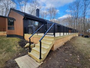 A newly built wooden deck featuring modern black cable railings and stairs, installed by H&M Fence, LLC in Norwalk, CT.