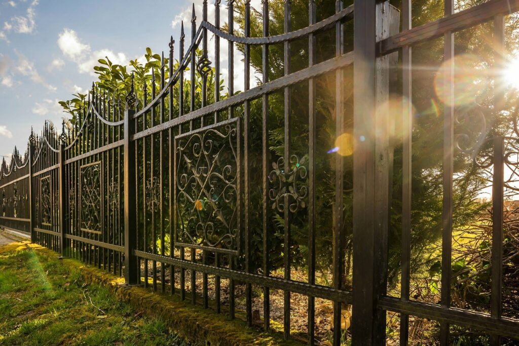 A long stretch of decorative black iron fence with intricate patterns installed by Ironcraft Welding in Chicago, IL.