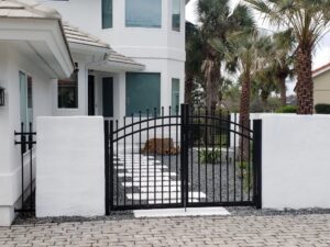 A decorative black metal gate installed at the entrance of a residential property by Best Fence and Rail in Jacksonville, FL.