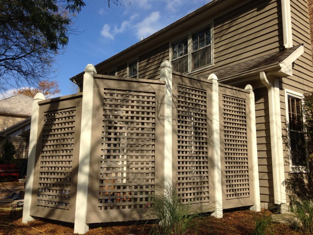 A decorative brown lattice fence installed next to a residential home by Fence Connection, Inc. in Elgin, IL.