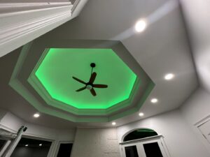A decorative ceiling with a ceiling fan and recessed lighting, featuring green accent lights, installed by Mark Anthony Electric LLC in Wilmington, DE