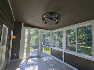 A decorative ceiling fan and an outdoor wall sconce installed in a sunroom by True Vine Electric in Raleigh, NC