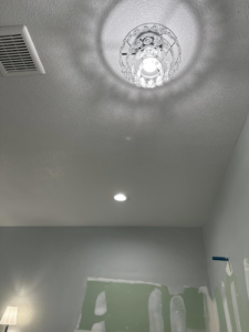 A decorative chandelier-style ceiling light and a recessed light installed in a room by Break-N-Run Services in Henderson, NV.