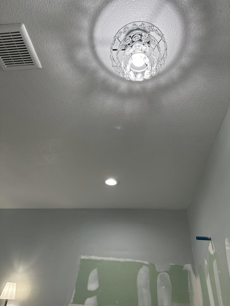 A decorative chandelier-style ceiling light and a recessed light installed in a room by Break-N-Run Services in Henderson, NV.
