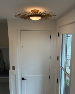 Decorative sunburst ceiling light and wall switch installed by Ampler Electrical Services in Wilmington, NC.