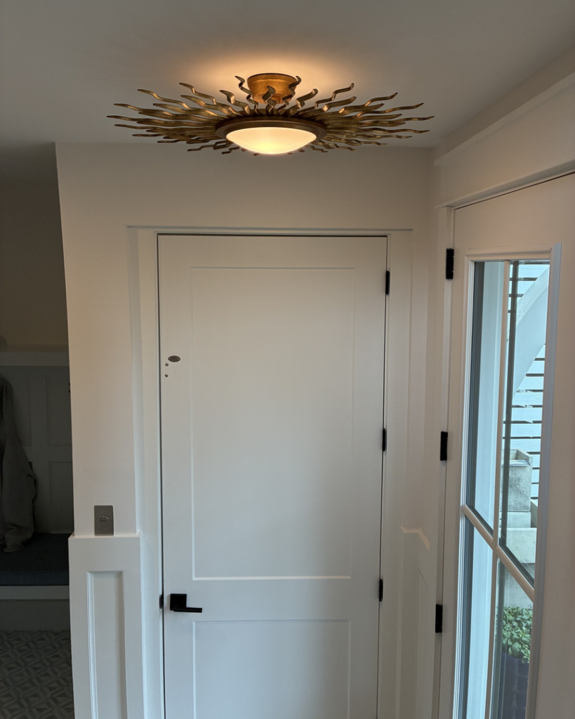 Decorative sunburst ceiling light and wall switch installed by Ampler Electrical Services in Wilmington, NC.