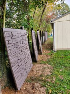Decorative fence panels being installed or prepared next to a chain link fence by Concord Fence Llc in Wilmington, DE
