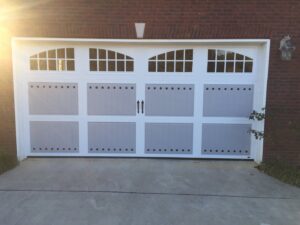 A stylish decorative garage door with arched windows and hardware installed by Precision Door Service of Huntsville, AL.