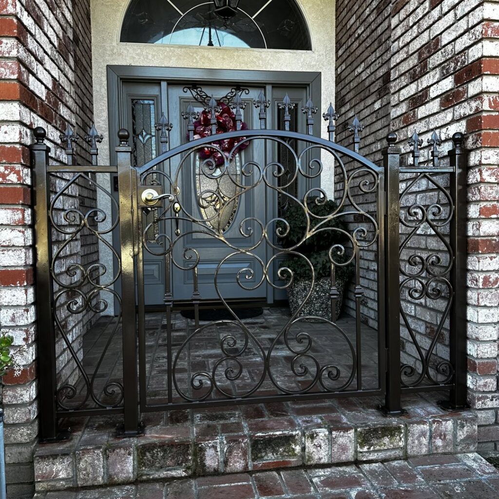 A decorative iron pedestrian gate at a house entrance, installed by Exclusive Custom Iron Works in Stockton, CA.