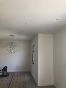 A room with a decorative light fixture and recessed lighting installed by CLB Electric Corporation in Norwalk, CA
